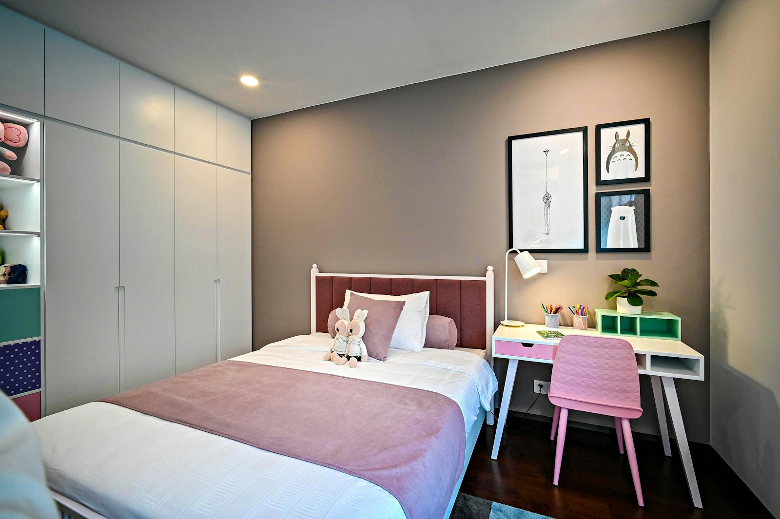 A calm, neutral corner of a family home arranged for a child, with soft seating and low shelving