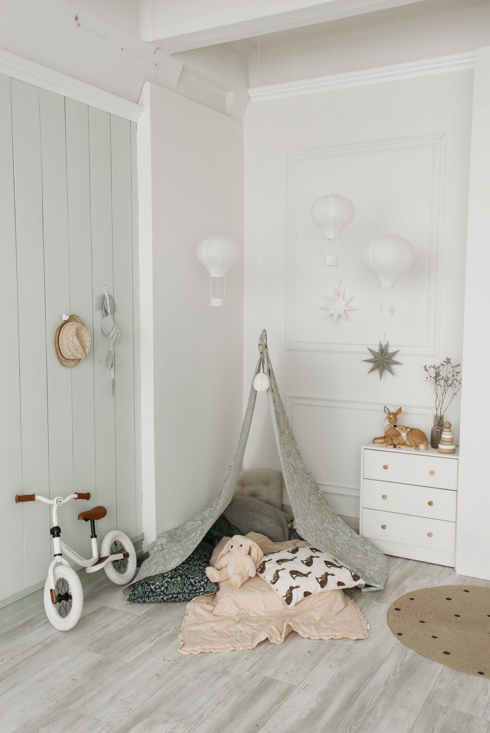 A cosy reading nook in a corner with soft seating, a small bookshelf, and warm lighting